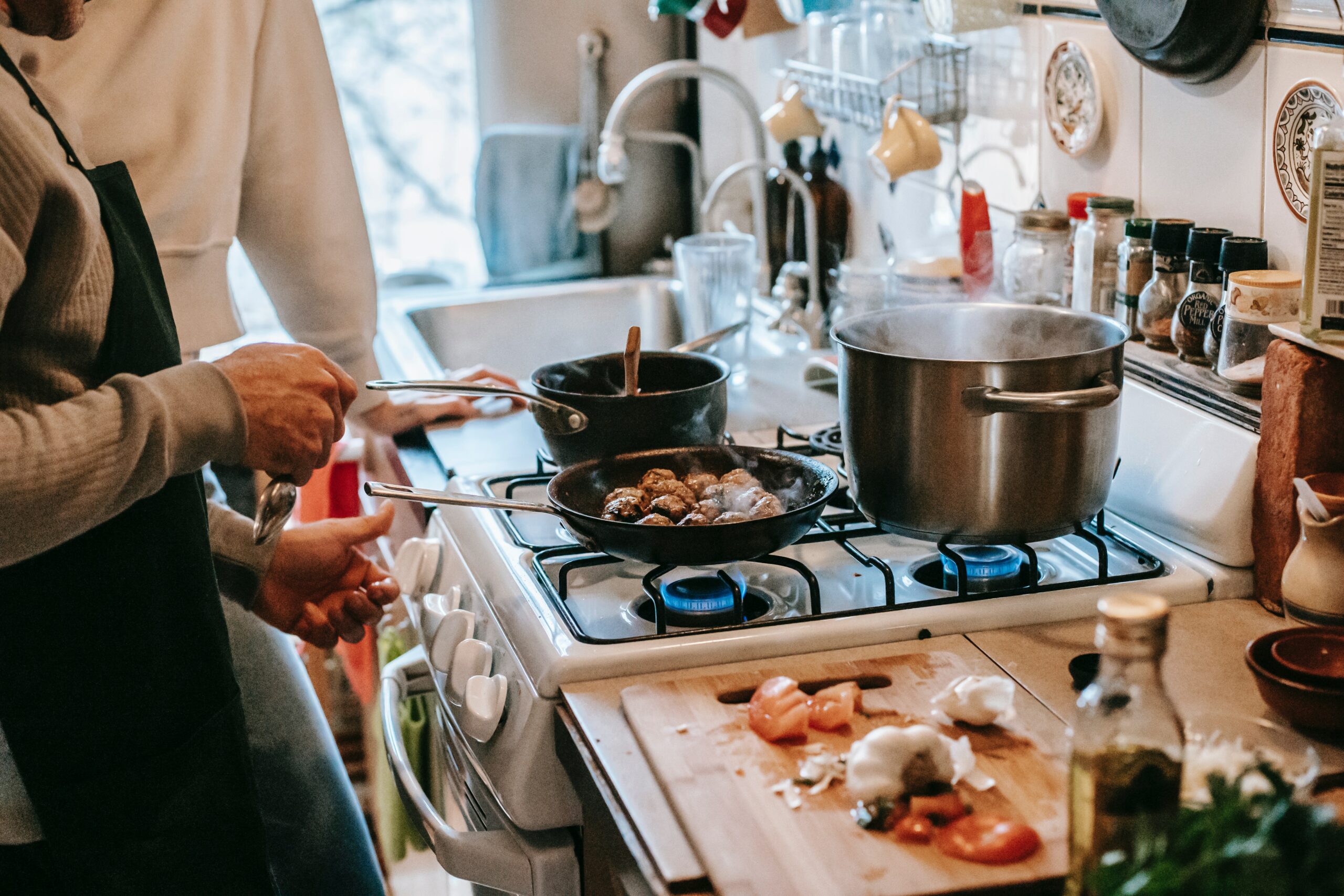 Couple using cookware on a gas stove