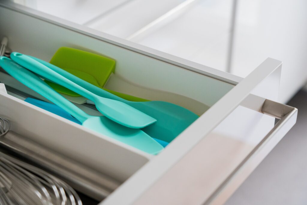Kitchen utensils stored in a drawer divider inside a drawer